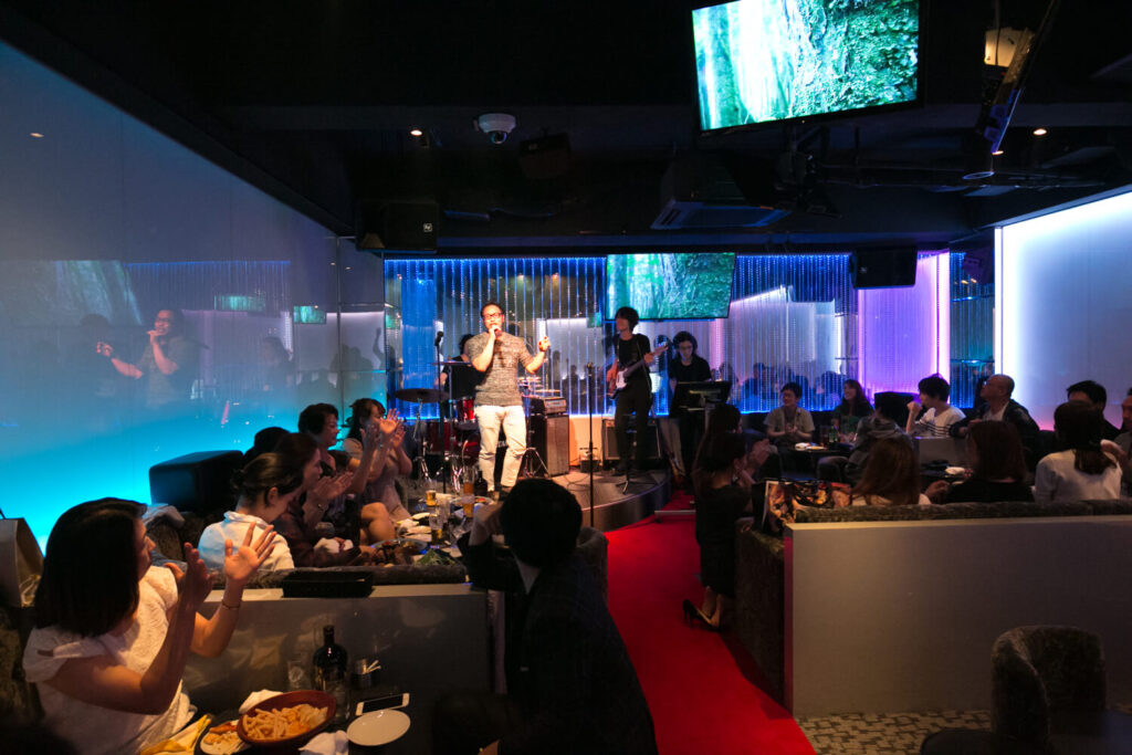 STAGEのステージで歌うシンガーに対して、観客が拍手を送るライブパフォーマンスの場面